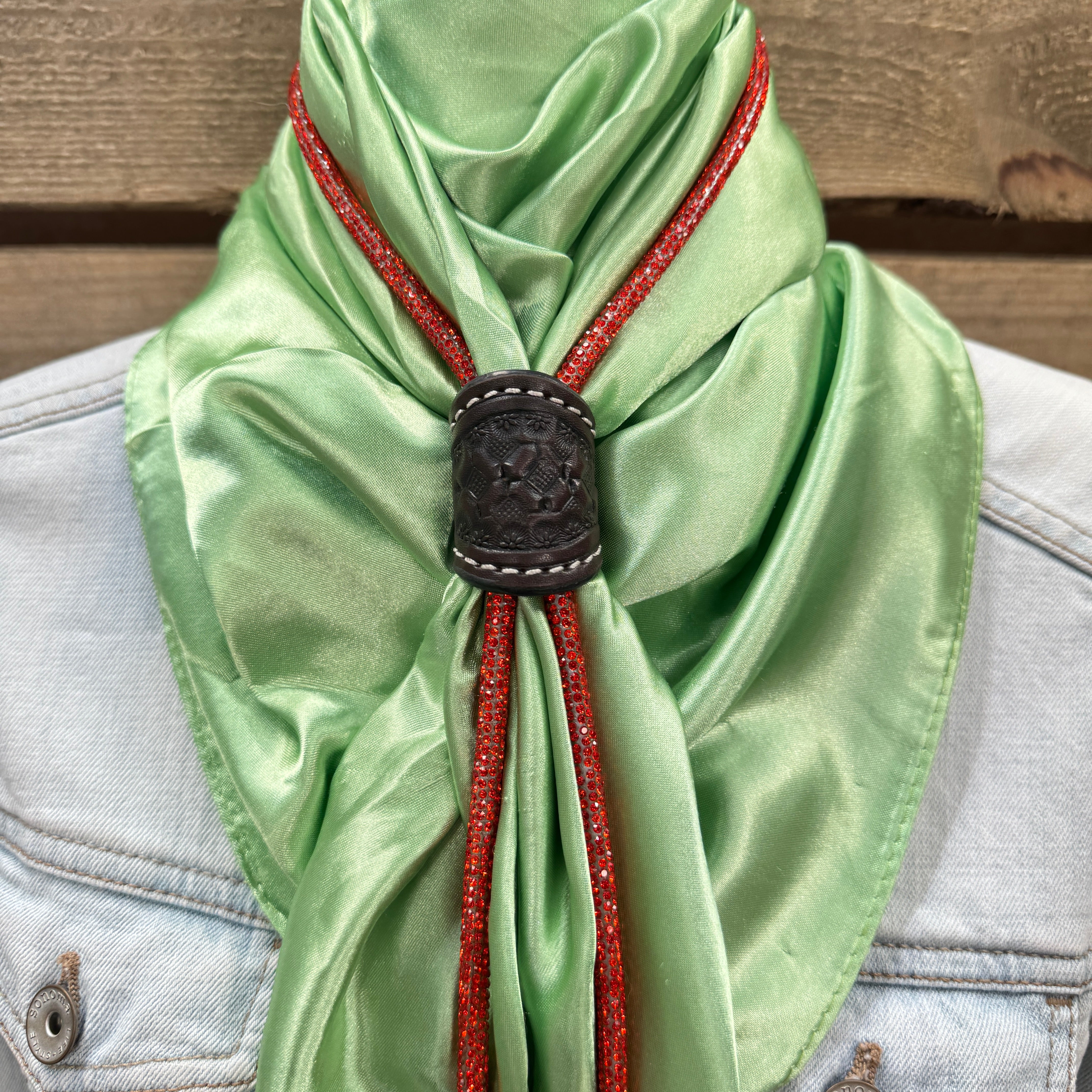 a green scarf with a black buckle on it