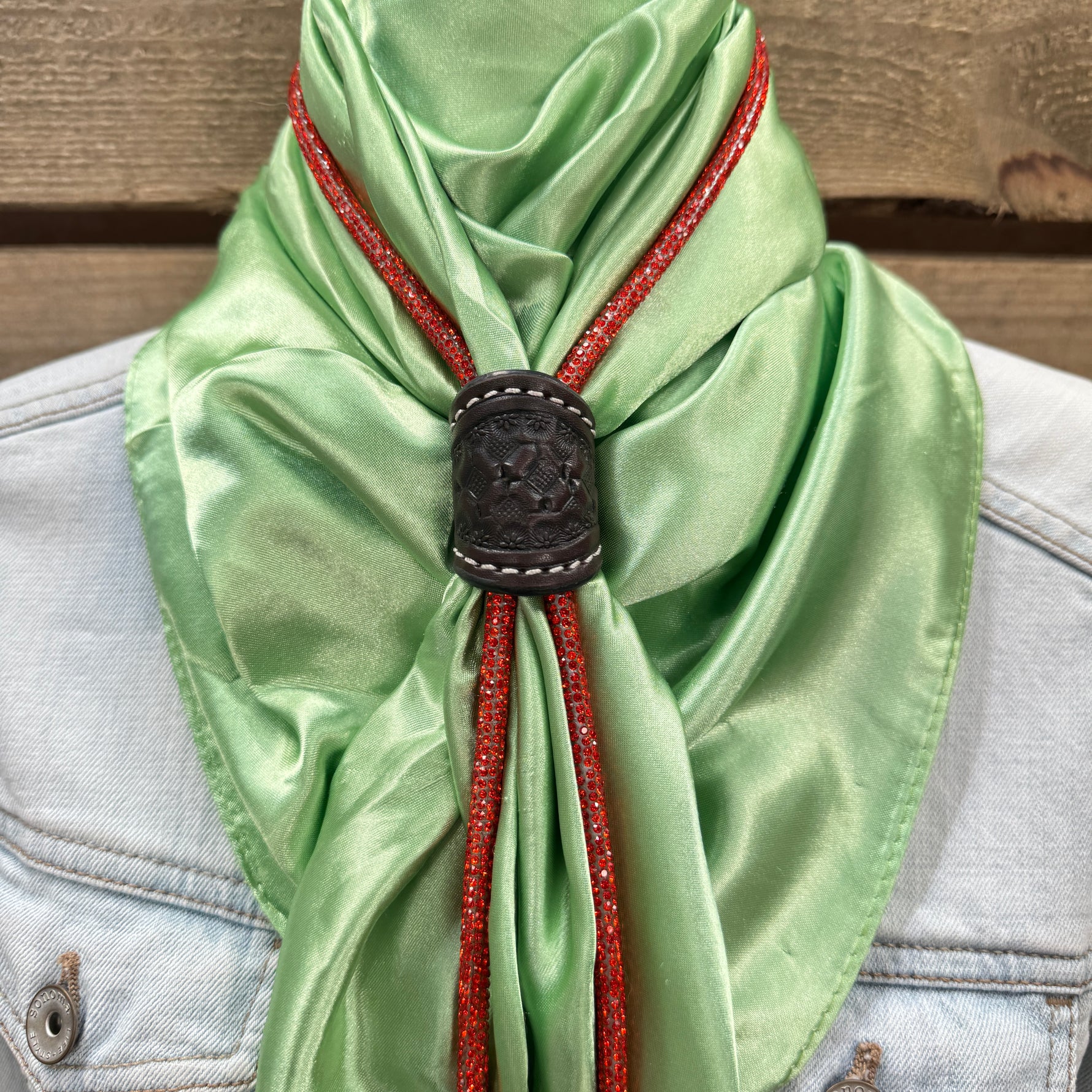 a green scarf with a black buckle on it
