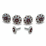 a pair of silver earrings adorned with red gemstones, including diamonds and rubies, set in a floral design.