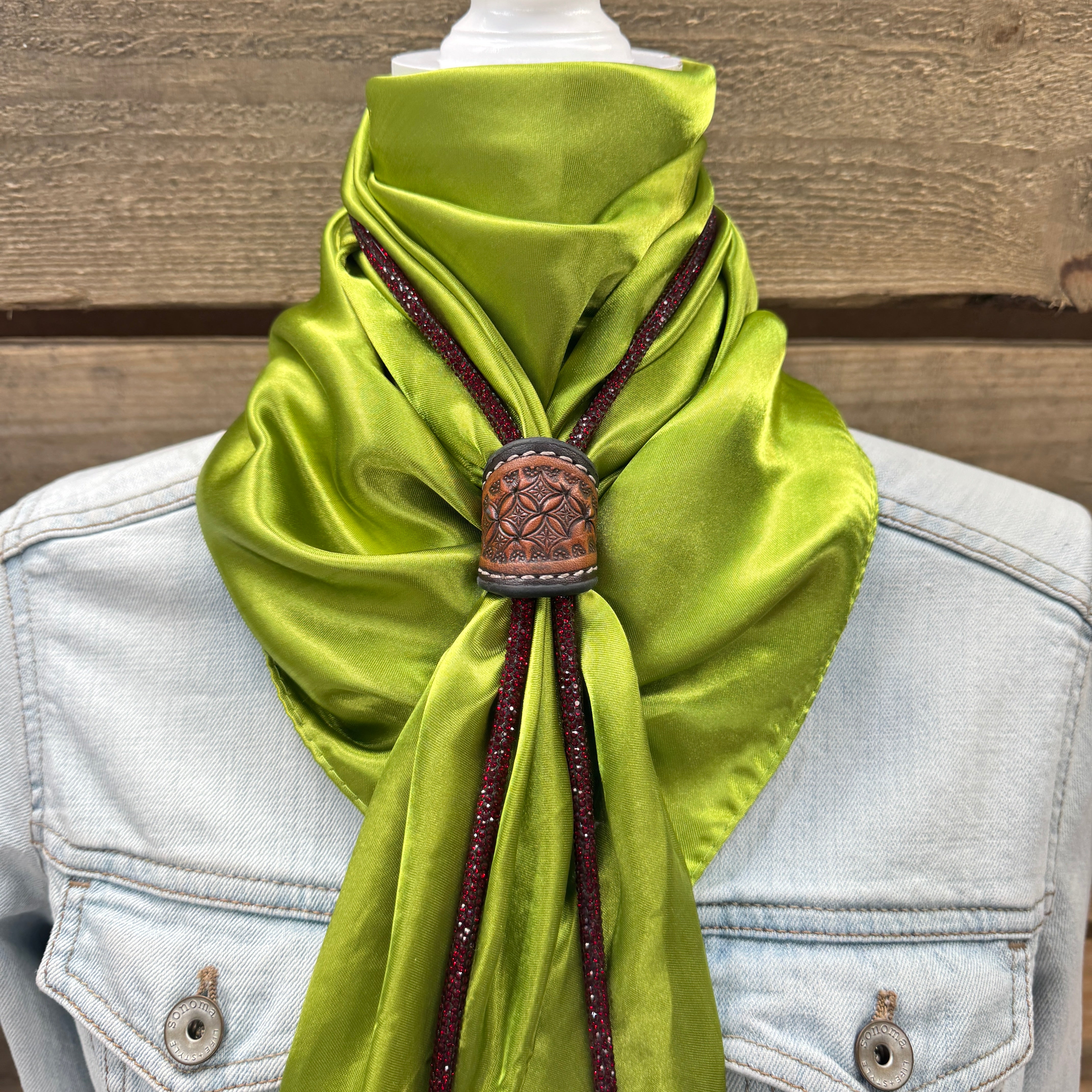 a green scarf tied to a jacket on a mannequin