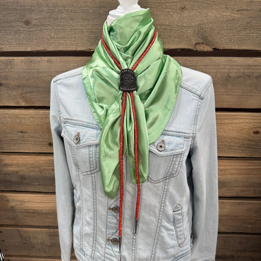 a green scarf tied to a jacket on a mannequin