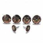 a collection of five round metal knobs with intricate designs, arranged in a row on a white background.