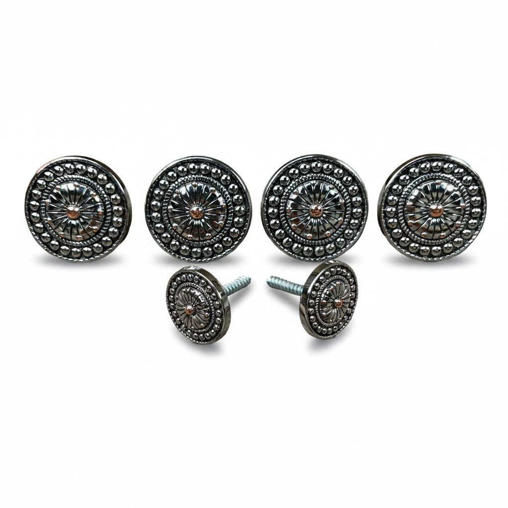 a collection of ornate, circular knobs or handles with intricate designs, including sunburst patterns and floral motifs, arranged in a row.