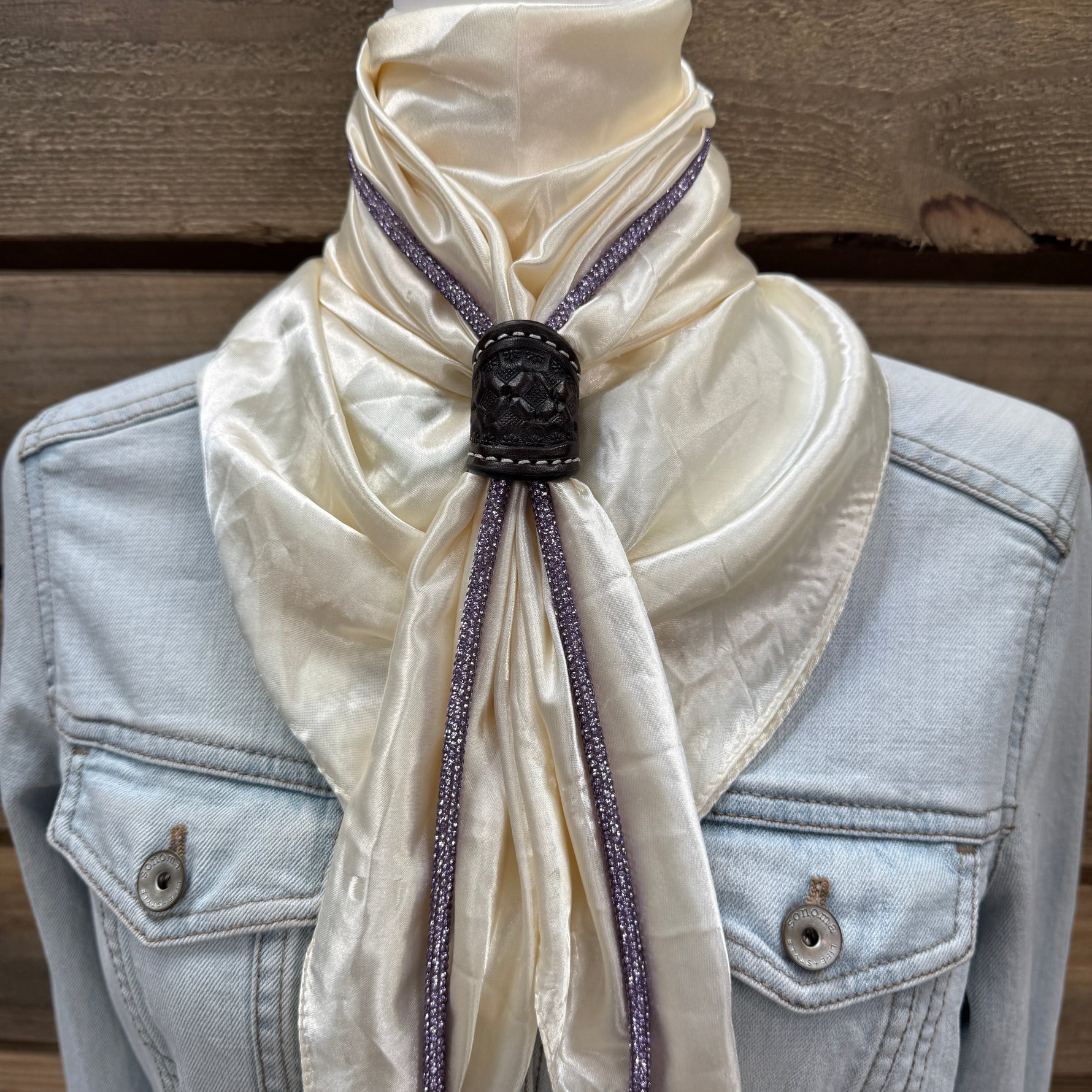 a white scarf tied to a jacket on a mannequin
