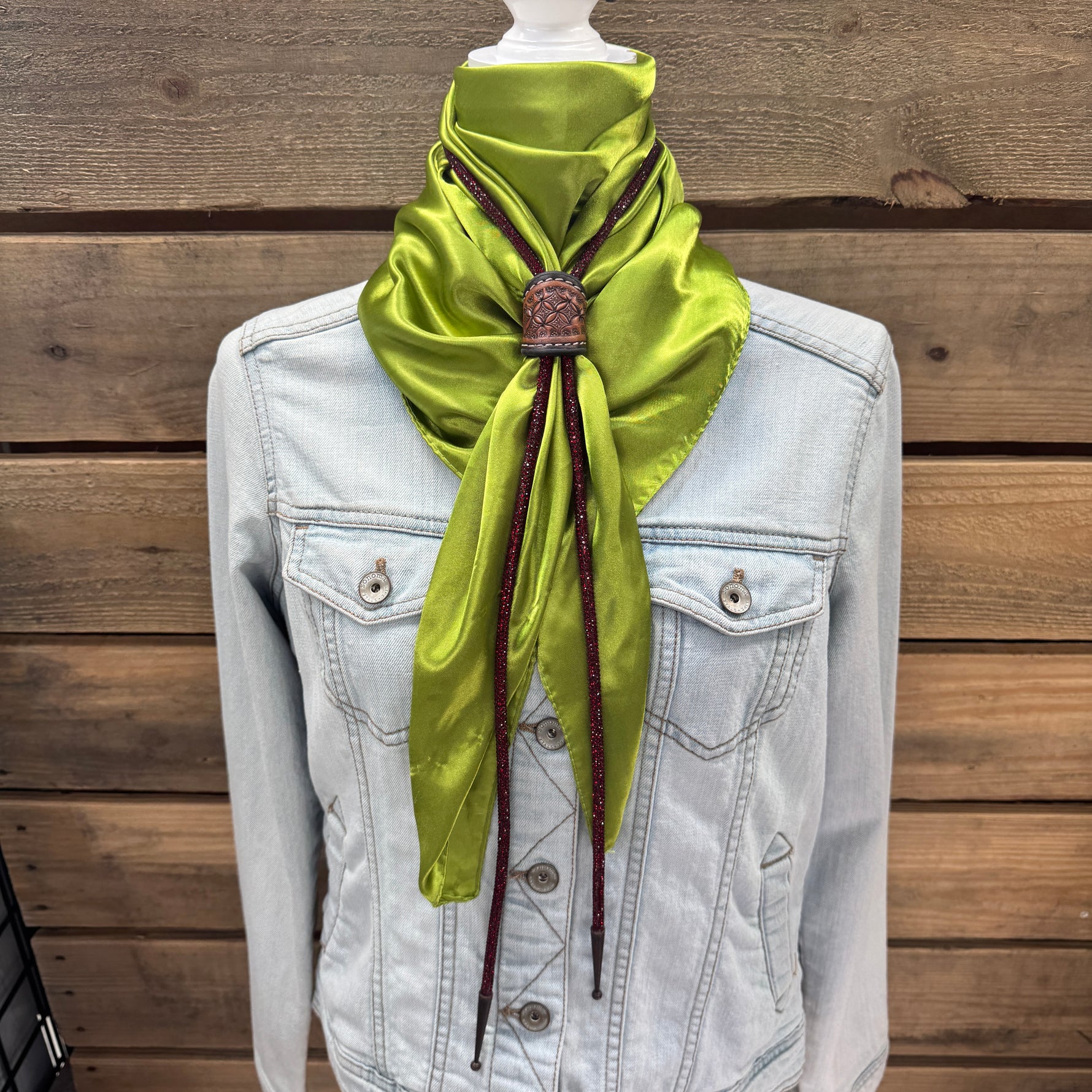 a white jacket and a green scarf on a mannequin