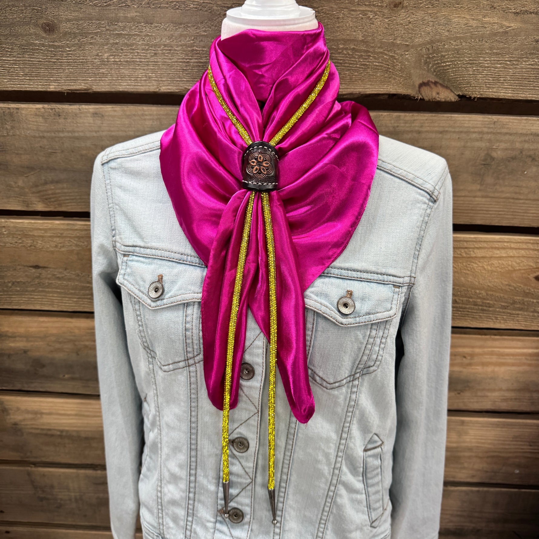 a woman wearing a denim jacket and a pink scarf