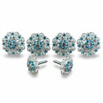 a collection of ornate, blue-toned jewelry pieces, including earrings and pendants, arranged in a row.