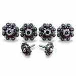 a collection of ornate, decorative buttons or knobs adorned with purple gemstones and intricate metalwork.