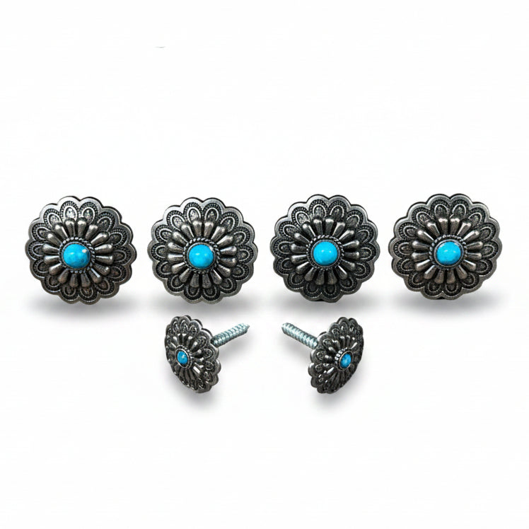 a collection of ornate silver knobs or handles with blue stones, arranged in a row.