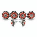 a pair of ornate earrings with red gemstones and intricate metalwork.