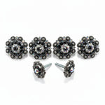 a pair of ornate, black and silver decorative buttons adorned with rhinestones and crystals.