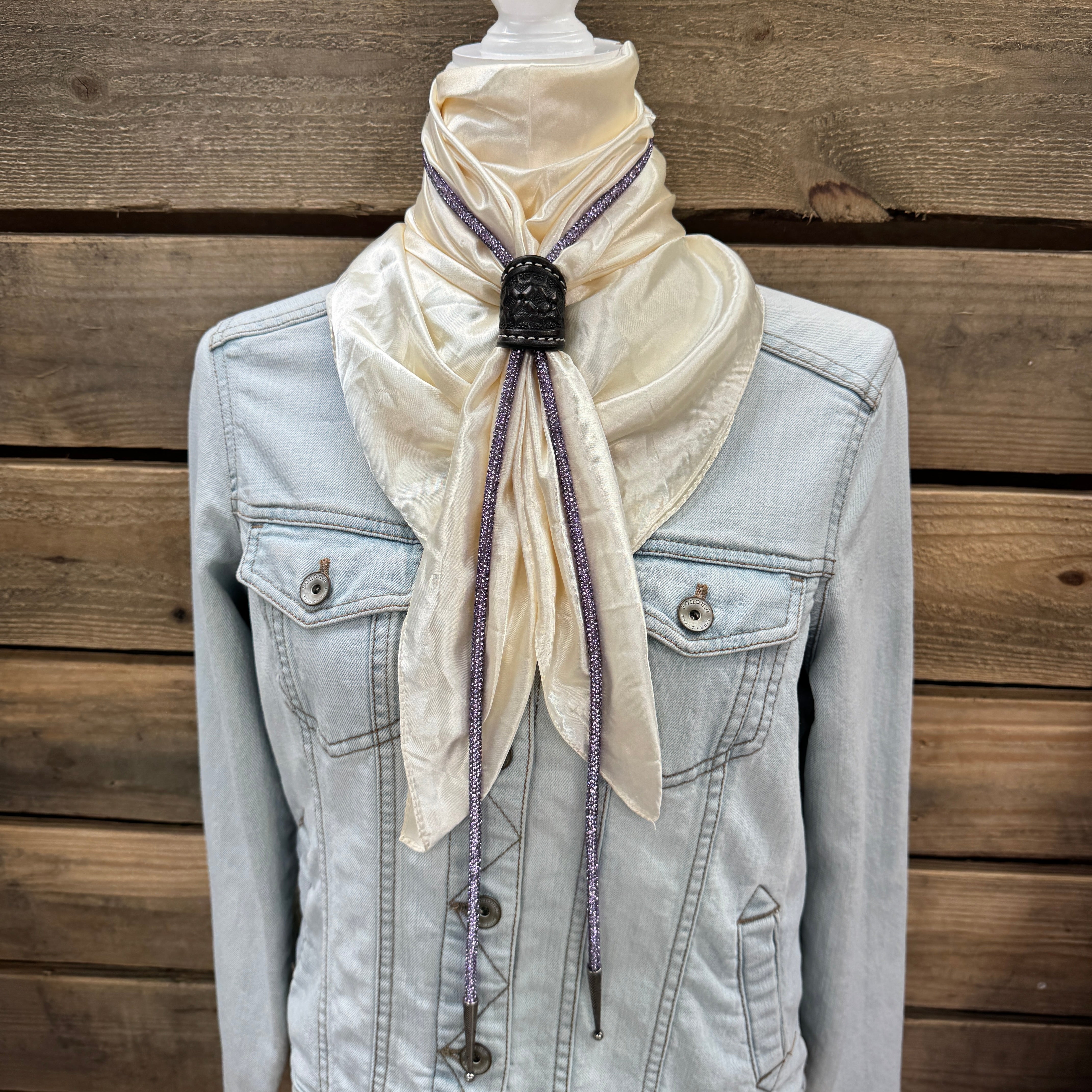 a white scarf tied to a jacket on a mannequin
