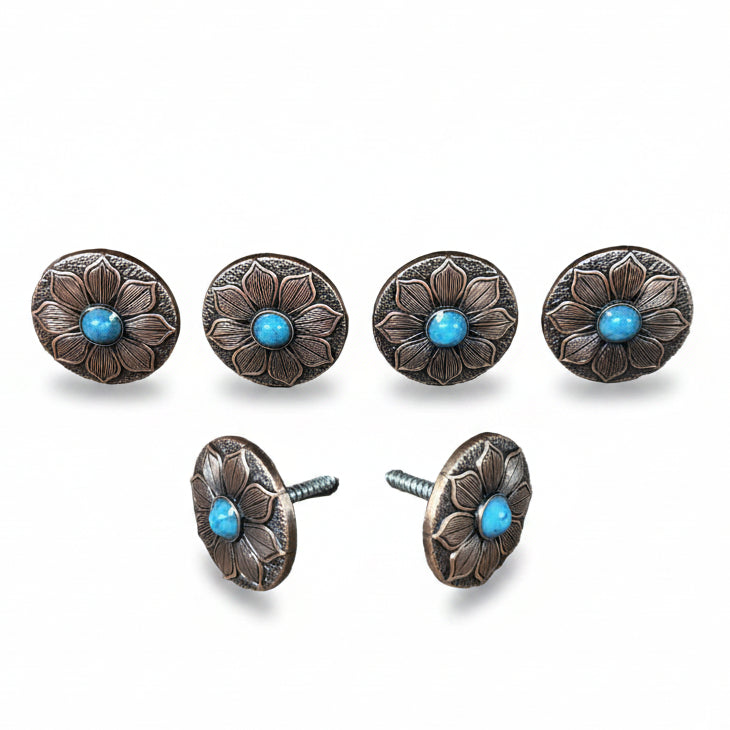 a collection of six ornate metal buttons with blue stones, arranged in two rows of three.