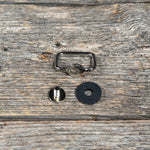 a metal ring, a rubber ring, and a black rubber ring placed on a wooden surface.
