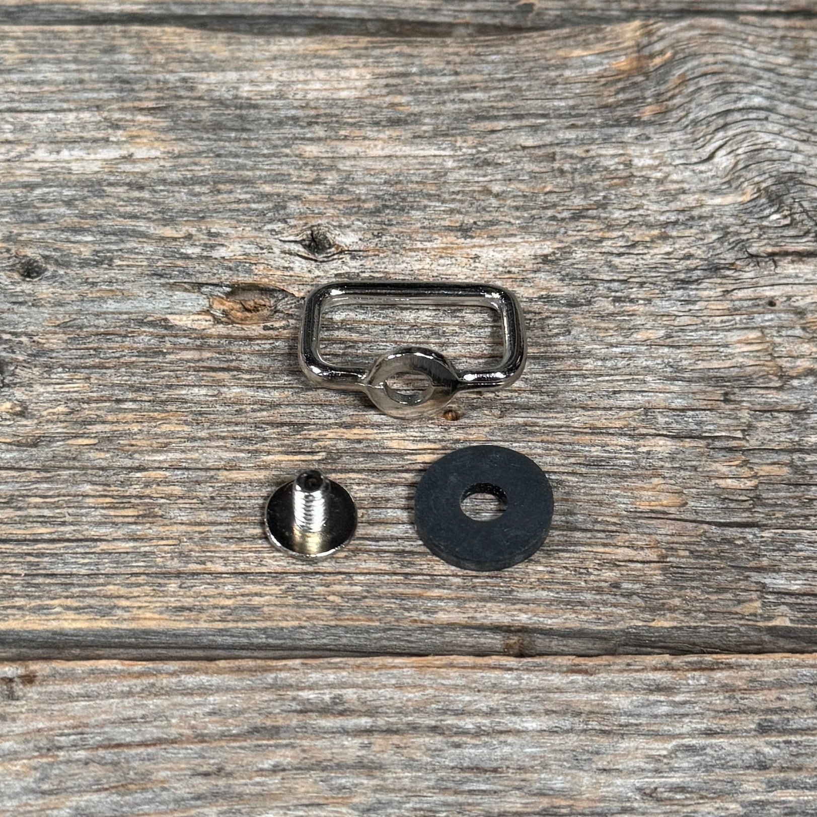 a metal ring, a rubber ring, and a black rubber ring placed on a wooden surface.