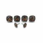 a set of ornate metal knobs or handles, each adorned with a decorative metal emblem. The knobs are arranged in a row, showcasing their intricate designs and craftsmanship.