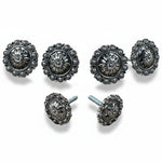 a collection of ornate, silver-colored metal buttons or knobs with intricate floral designs.