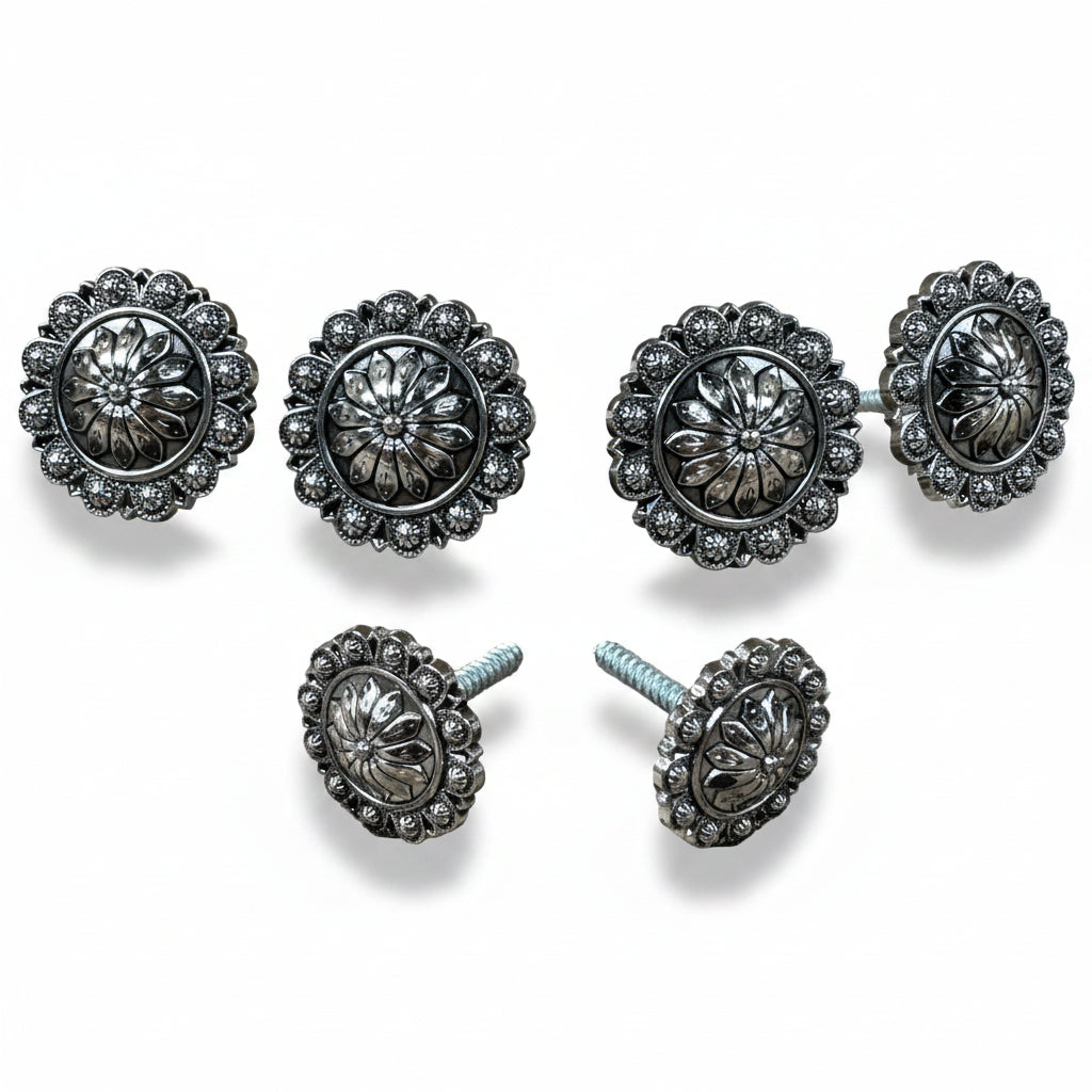 a collection of ornate, silver-colored metal buttons or knobs with intricate floral designs.