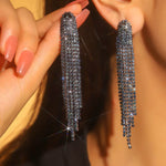 Sparkling crystal fashion earrings held by a hand with a blurred background