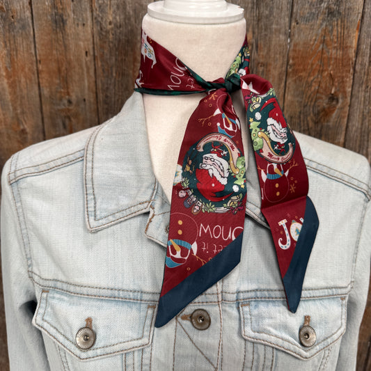 Mannequin wearing a denim jacket with a festive red scarf against a wooden background