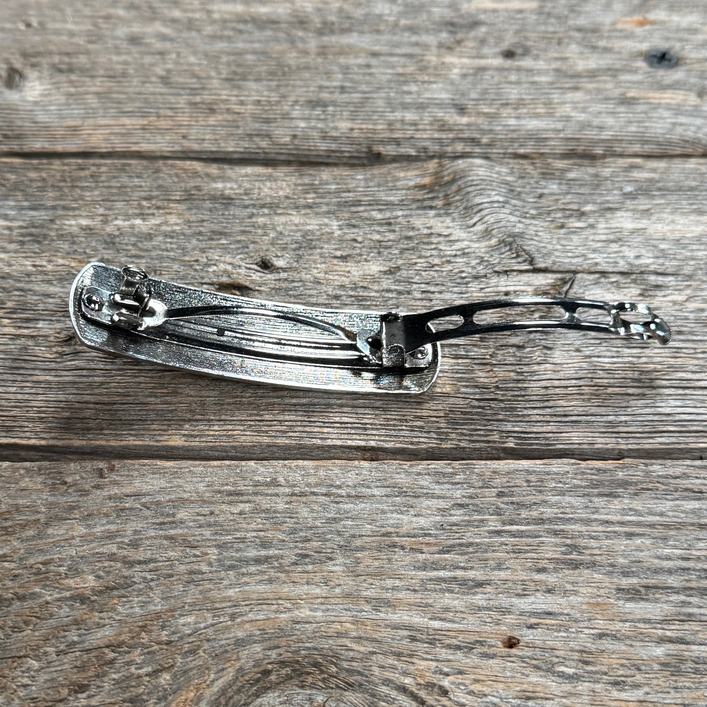 Decorative hair accessory back clip on a wooden surface | rodeo drive conchos | 