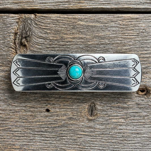 Silver hair accessory with turquoise stone on a wooden surface | rodeo drive conchos |