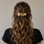 Person with wavy hair wearing a gold hair clip with a turquoise stone on a neutral background | rodeo drive conchos |