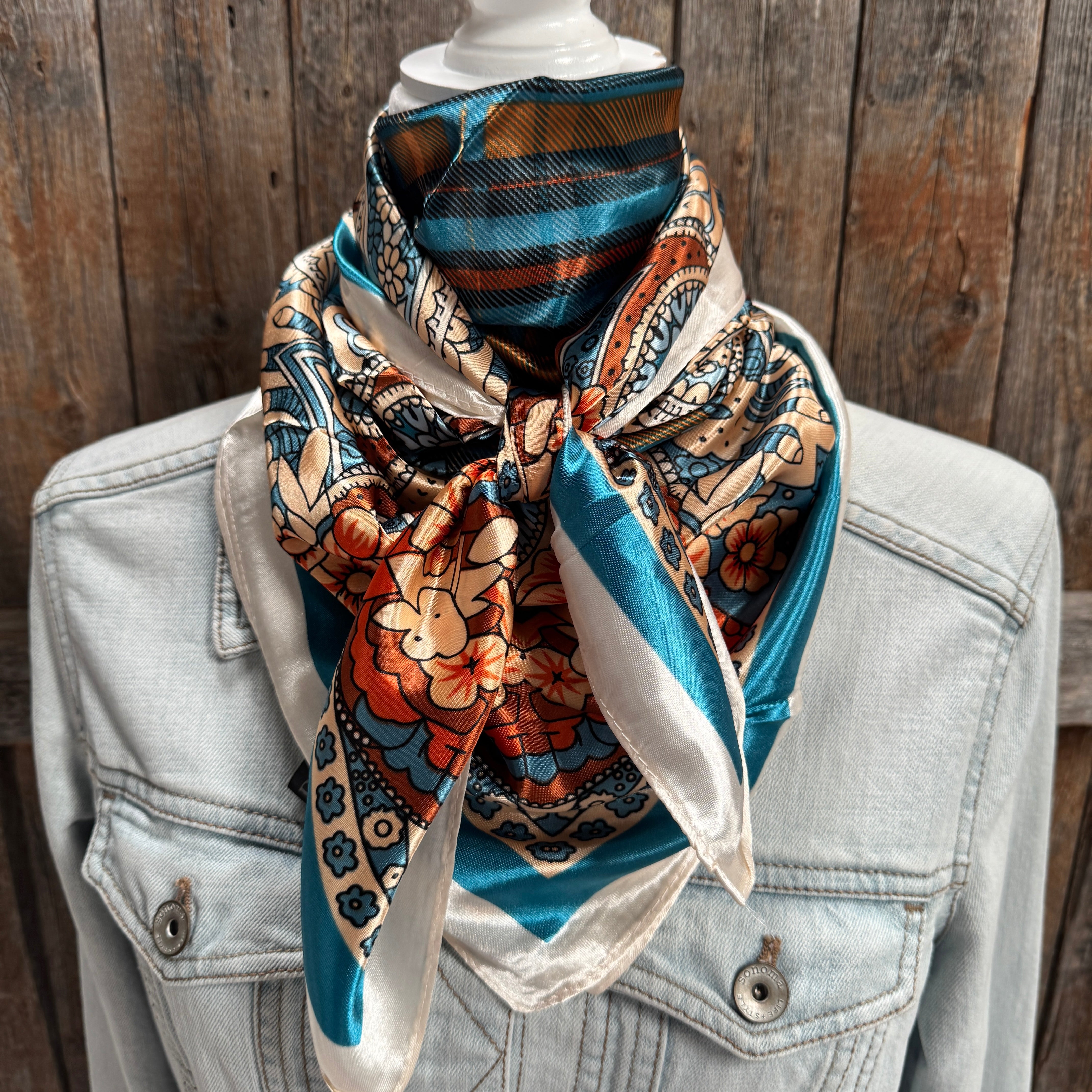 wild rag scarf draped over a denim jacket against a wooden background