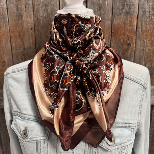 Patterned scarf draped over a light blue denim jacket against a wooden background