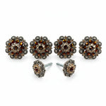 a set of ornate, decorative knobs or handles, each adorned with a large, sparkling gemstone. The knobs are arranged in a row, with two of them being the focal point. The background of the image is plain white, which allows the knobs and their intricate designs to stand out prominently.