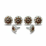 a pair of ornate earrings with a floral design and sparkling gemstones.