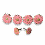 a collection of pink flower-shaped knobs or handles, each adorned with a gold center and a silver screw. The knobs are arranged in a row, with two of them placed next to each other.