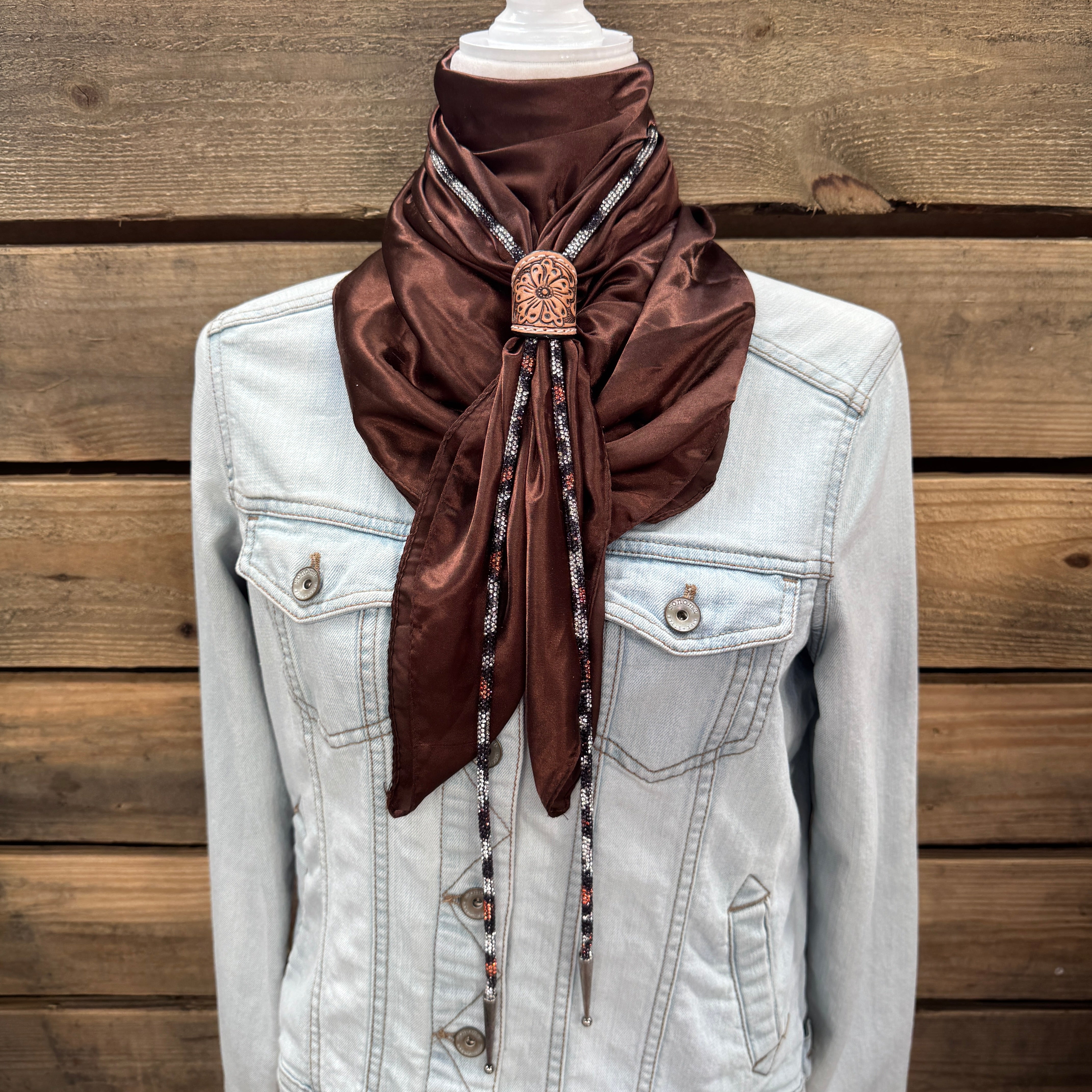 a white jacket with a brown scarf on top of it