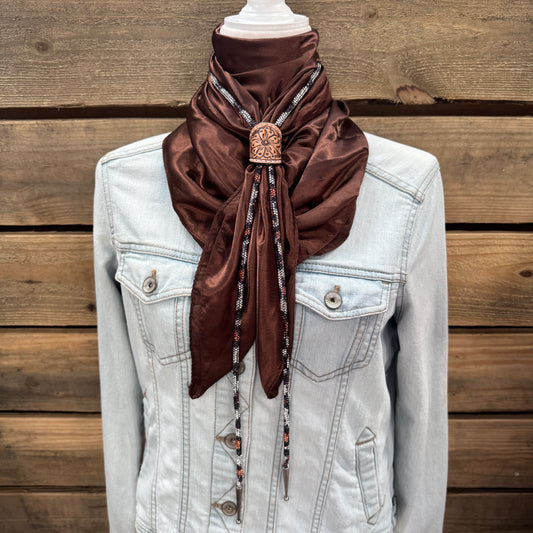 a white jacket with a brown scarf on top of it