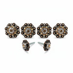 a set of ornate, decorative knobs or handles, each adorned with a floral design and embellished with small, sparkling stones or crystals. The knobs are arranged in a row, with two of them being the closest to the viewer and the others positioned further back.
