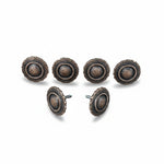 a collection of six ornate, circular knobs or handles with a metallic, textured finish. The knobs appear to be made of a dark material and are arranged in a row, with some of them facing forward and others facing backward.