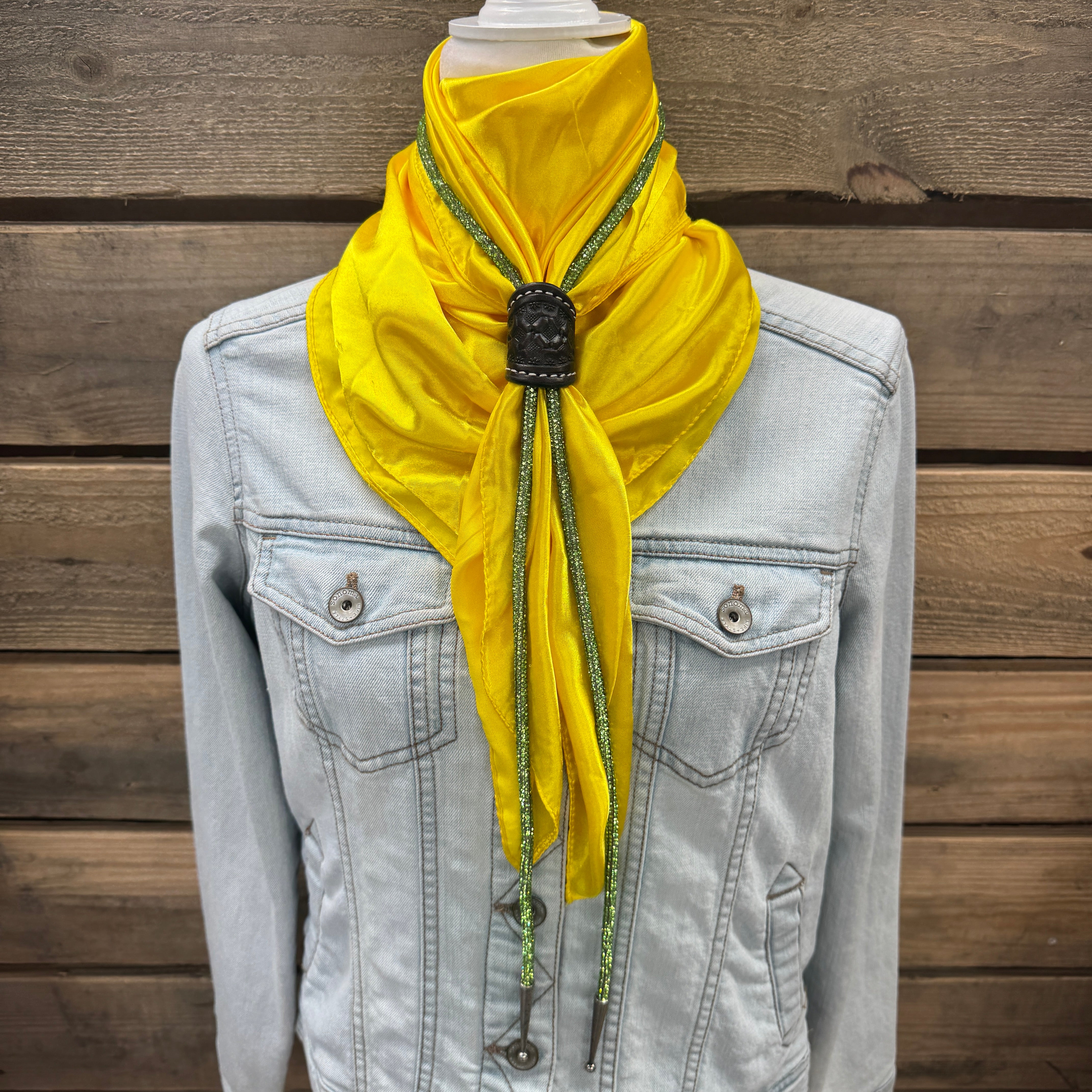 a yellow scarf hanging from a jacket on a mannequin