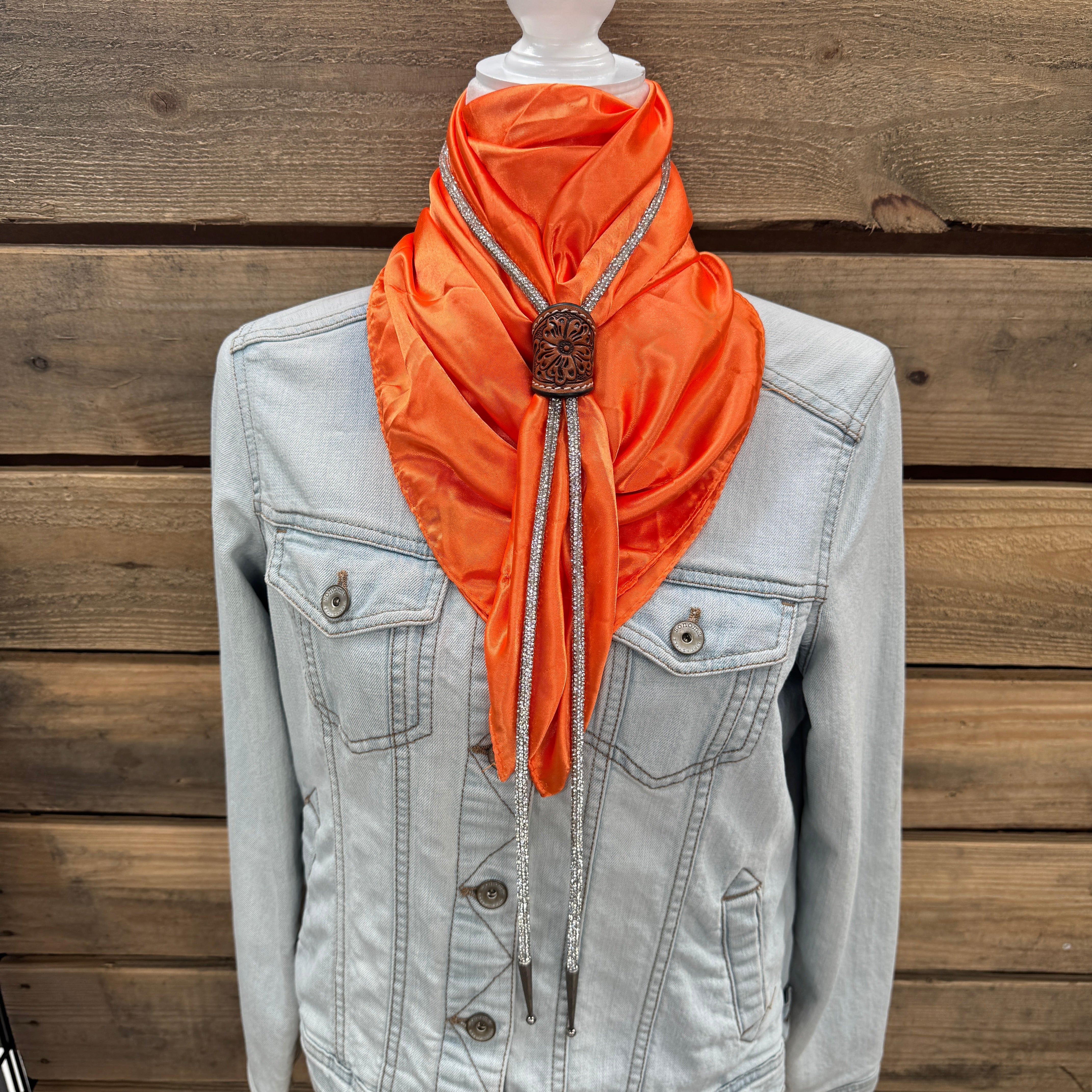 a denim jacket with an orange scarf tied to it