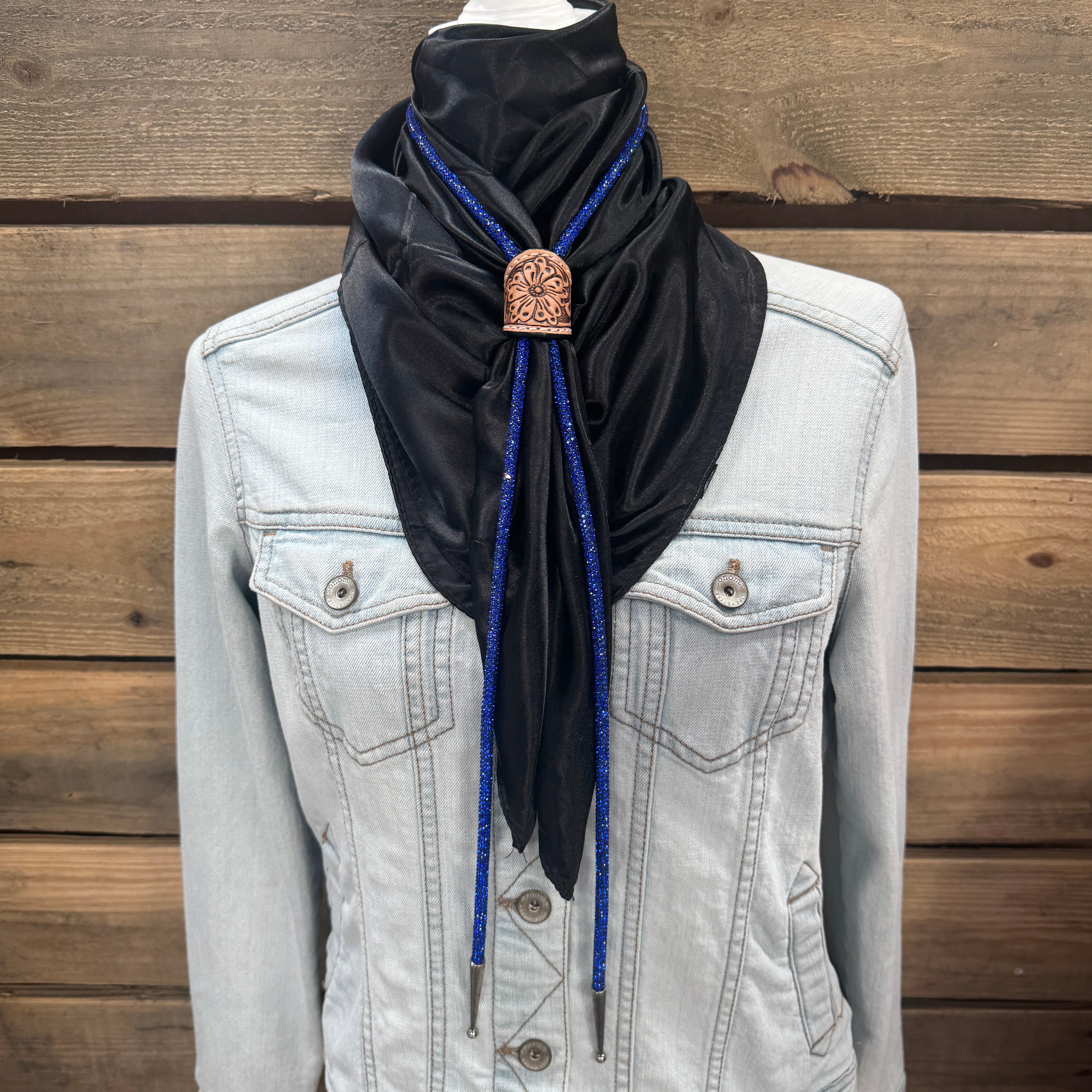 a woman wearing a black scarf and a denim jacket