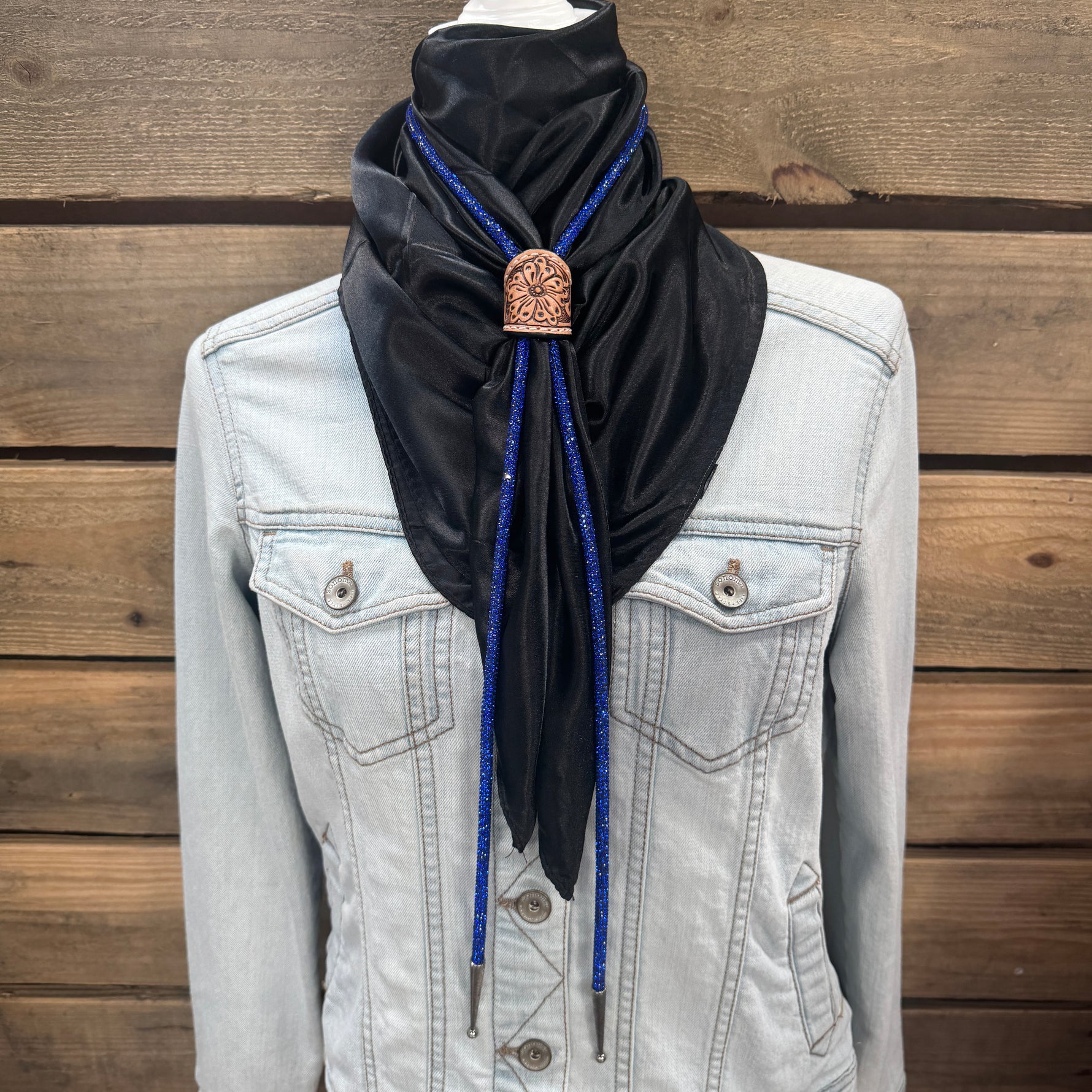 a woman wearing a black scarf and a denim jacket
