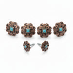 a collection of ornate, decorative metal pieces, including knobs and earrings, with turquoise stones.